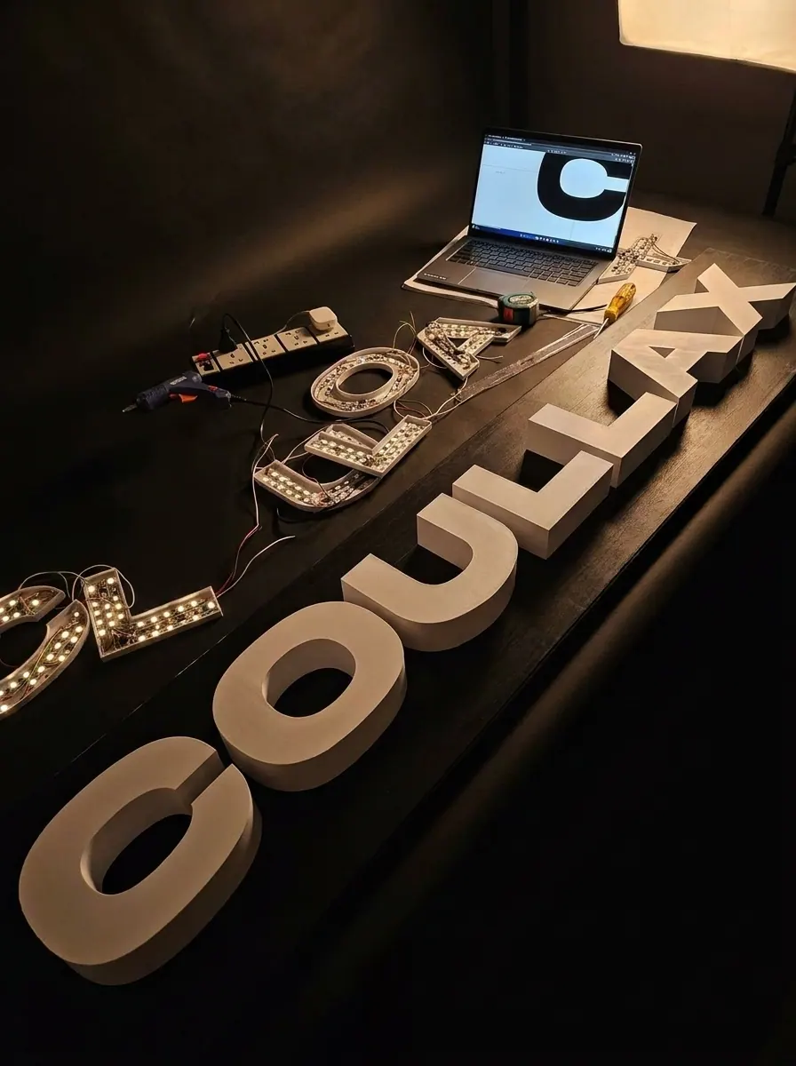 Built-up white 3D letters for an illuminated LED sign board during assembly with LED strips